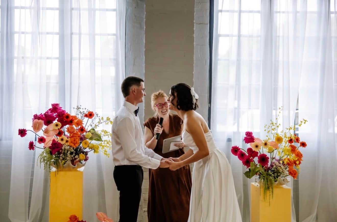 A couple holding each other at golden hour, the bride’s veil lifting in the light