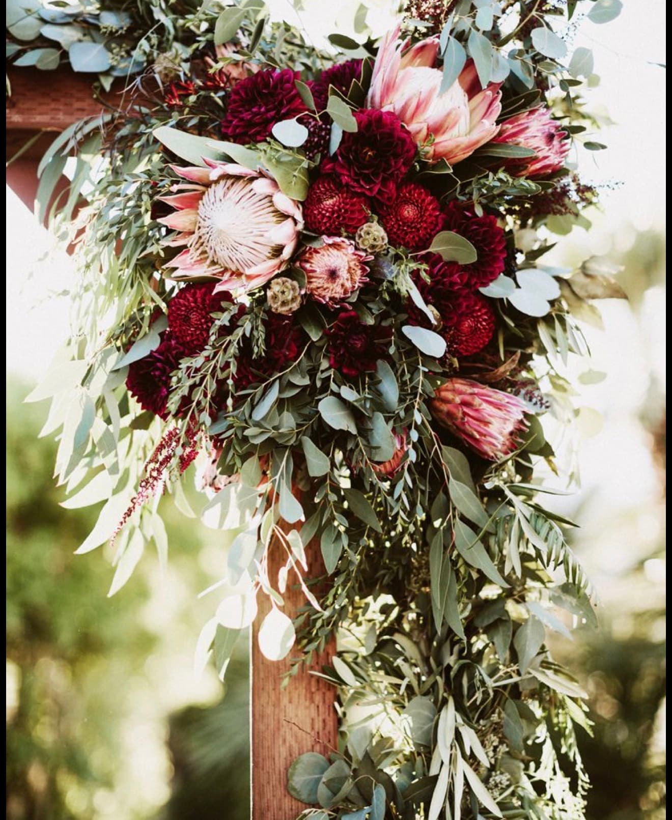 Peach and cream blooms with daisies and eucalyptus, arranged close up